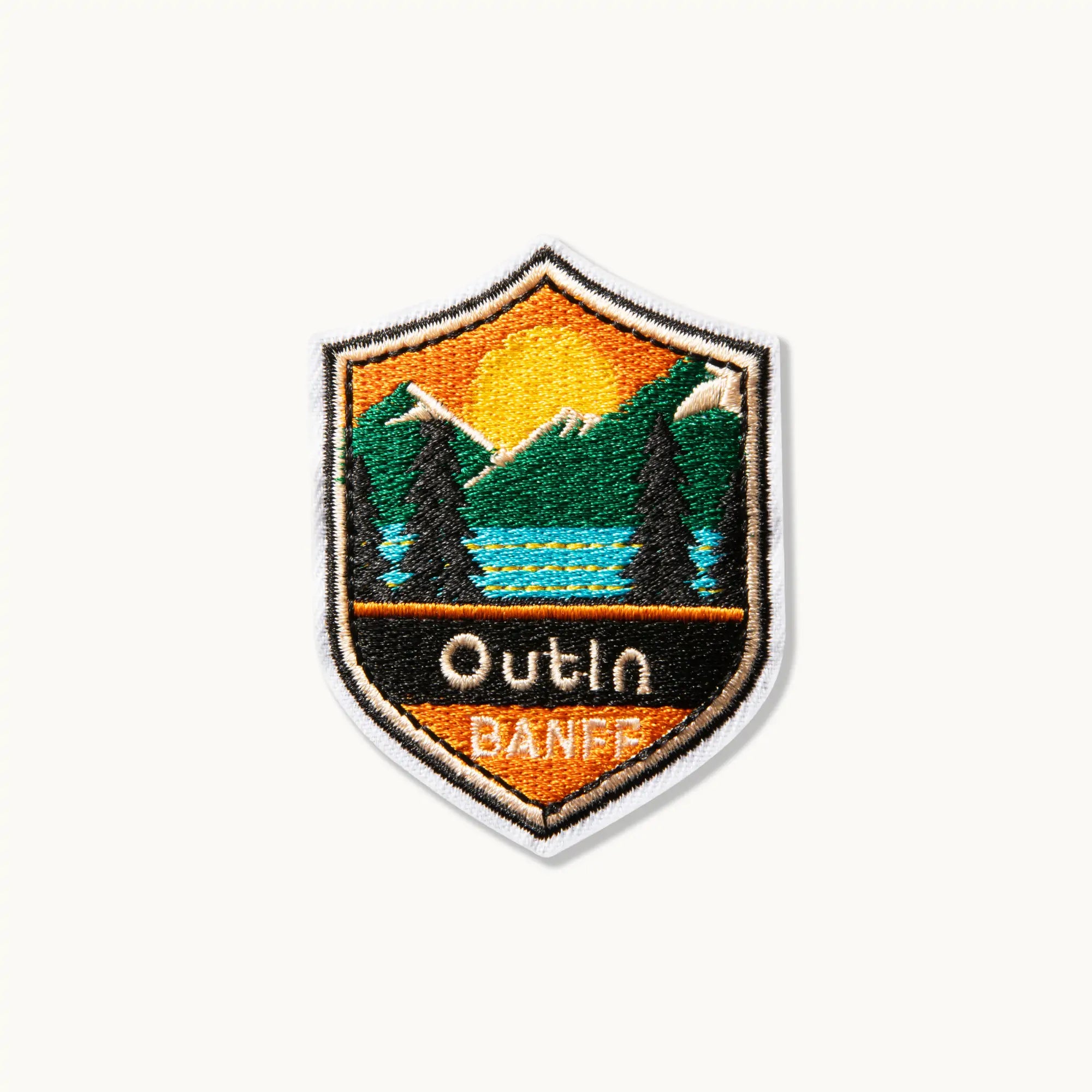 Outin Banff Patch - Embroidered patch with mountain landscape and Outin logo.